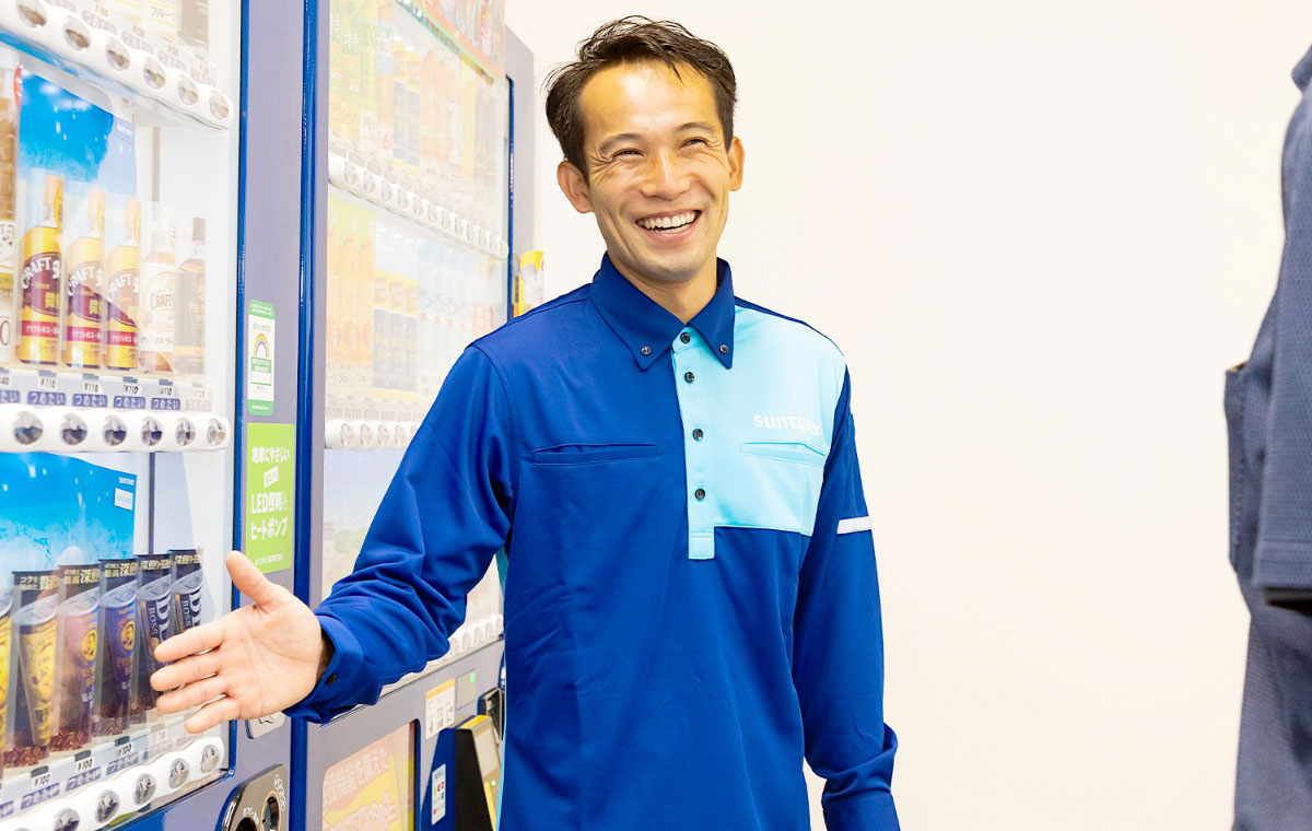 自動販売機の前でお客様に笑顔で提案している様子